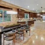 he grand foyer leads to the formal living room with 25+ ft. ceilings and a wraparound staircase. Gourmet kitchens feature Viking appliances, a built-in breakfast bar, and custom European cabinetry. Upstairs, the spacious primary suite features a fireplace and a luxurious ensuite bathroom with a steam shower, soaking tub, and two walk-in closets. A movie theater completes the main house.