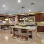 he grand foyer leads to the formal living room with 25+ ft. ceilings and a wraparound staircase. Gourmet kitchens feature Viking appliances, a built-in breakfast bar, and custom European cabinetry. Upstairs, the spacious primary suite features a fireplace and a luxurious ensuite bathroom with a steam shower, soaking tub, and two walk-in closets. A movie theater completes the main house.